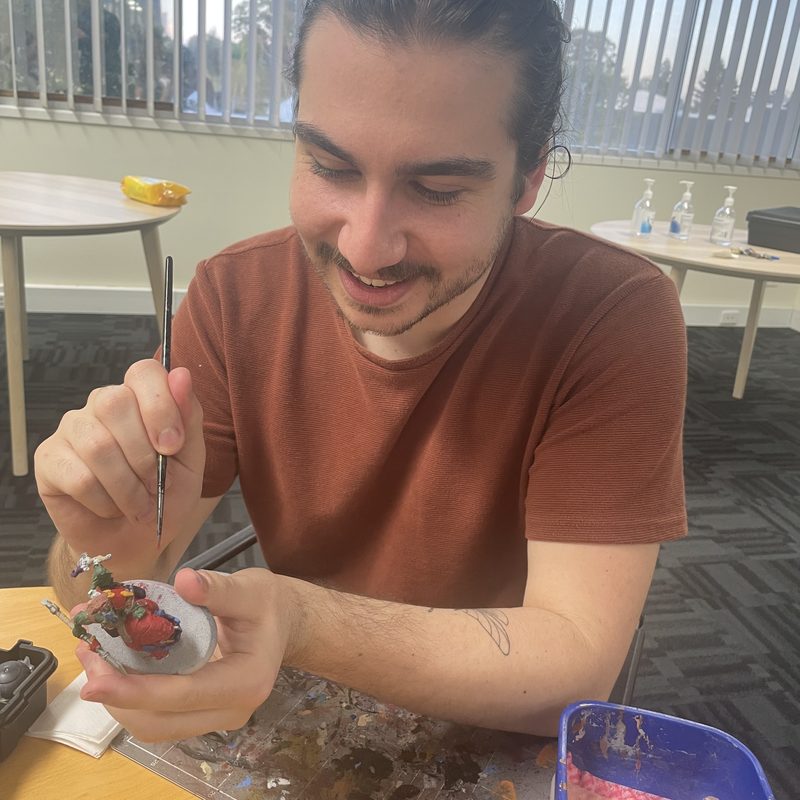 Painting a fantasy miniature at the table