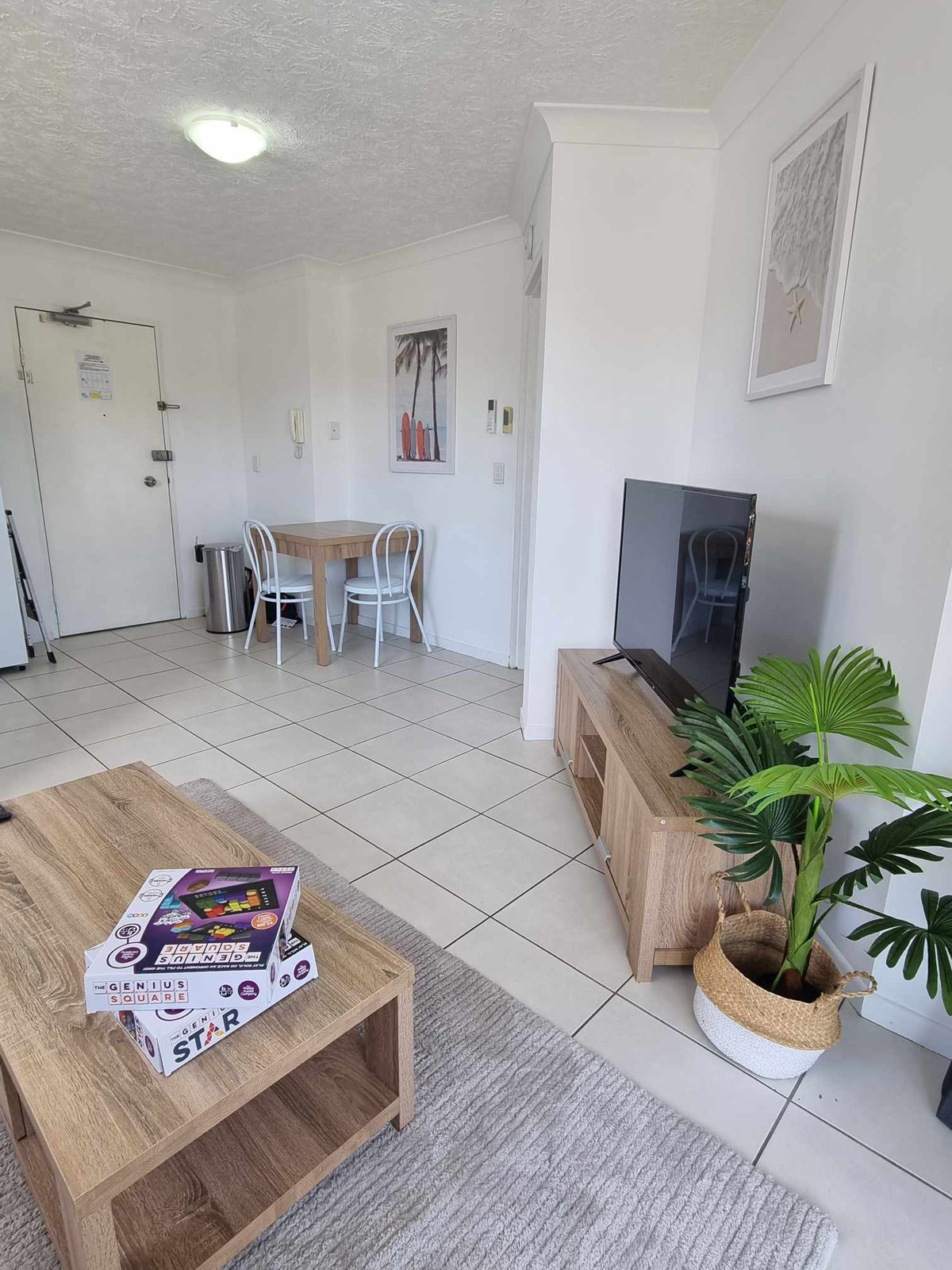 A bright open living space with a dining table, lounge and front door
