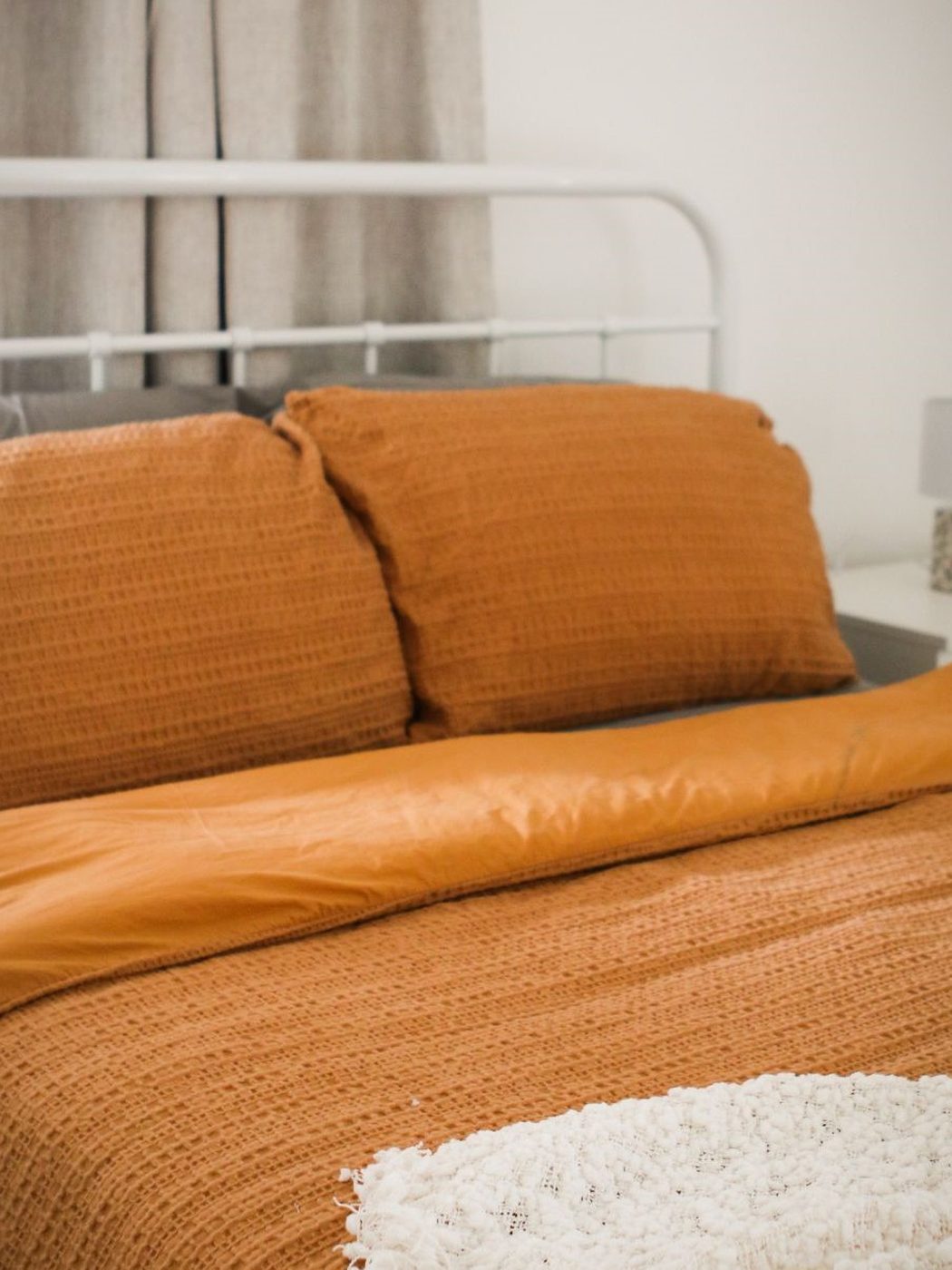 A bed made up in terracotta linen
